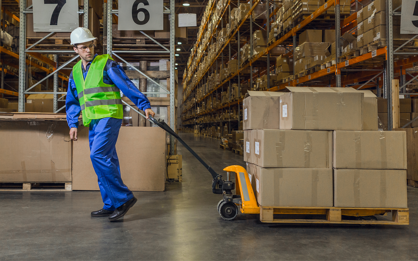 Warehouse worker dragging a cart with boxes